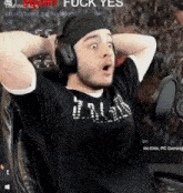 a man wearing headphones is sitting in front of a microphone and making a funny face .