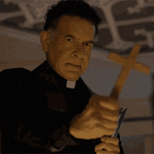 a priest is holding a cross and a knife in his hands