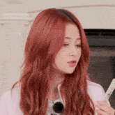 a woman with red hair has a remote control in her hand