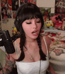 a woman wearing headphones and a braided hairstyle is talking into a microphone