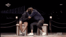 a man and a woman are kissing in front of a tv8 hd screen