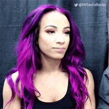 a woman with purple hair is wearing a black tank top and making a face .