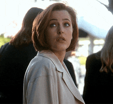 a woman with a surprised look on her face stands in a crowd
