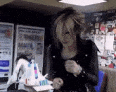 a woman in a black jacket is standing in front of a pocari sweat machine .