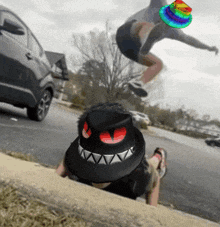 a person wearing a black hat with red eyes is laying on the side of the road