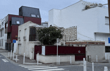 a street corner with a red fence and a blue sign that says ' n ' on it