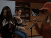 a man and a woman are sitting in a room with a piano on the wall