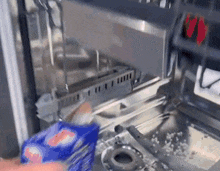 a person is cleaning a dishwasher with a bag of soap .