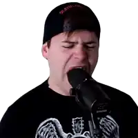 a man singing into a shure microphone while wearing a deathstar hat