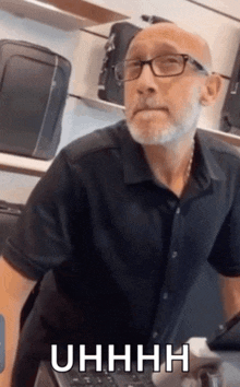 a bald man wearing glasses and a black shirt says uhhhh