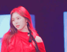 a woman with red hair wearing a red top