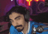 a man with a beard is wearing headphones and a blue shirt .