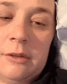 a woman is laying in bed with a mask on her face .
