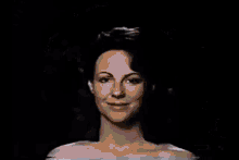 a woman without a shirt is standing in front of a blue and yellow circle .