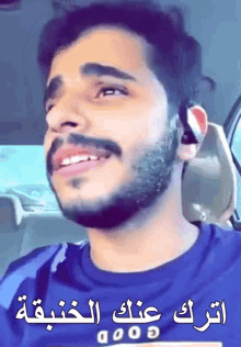 a man with a beard wearing a blue shirt that says good on it