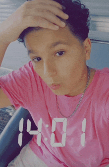 a person wearing a pink shirt with the time 14:01 on it