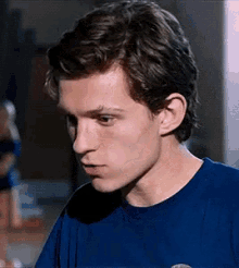 a close up of a young man wearing a blue t-shirt .