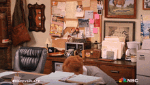 a nbc ad for happy 's place shows a man sleeping at a desk