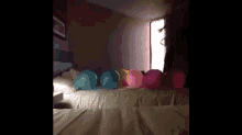 a bunch of colorful balloons are sitting on a bed