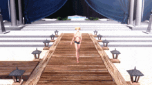 a woman in a bikini walks along a wooden walkway