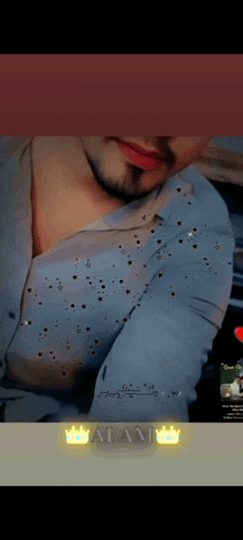 a man with a beard is wearing a blue shirt with gold stars on it .
