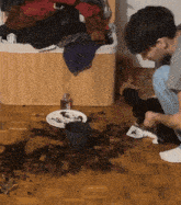 a bottle of eau de toilette sits on a messy floor next to a plate