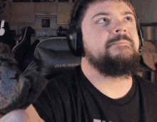 a man with a beard is wearing headphones and a black shirt with the word dxr on it