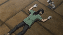 a man in a green shirt is laying on the floor surrounded by cans