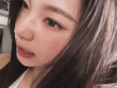a close up of a woman 's face with a sign in the background that says ' tokyo ' on it