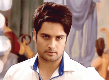 a man wearing a white shirt has a blue collar