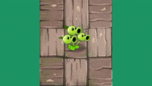 a group of green plants with their mouths open are standing next to each other on a wooden surface .