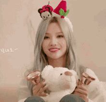 a woman wearing a santa hat is holding a bell in front of her ear