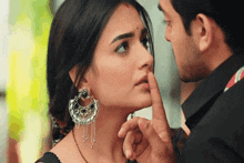 a man holds his finger to a woman 's mouth
