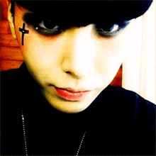 a close up of a person 's face with a cross on their face