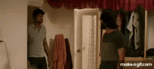 two men are standing in a room in front of a closet .