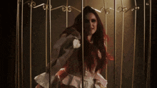 a woman with long red hair is standing in a dark room