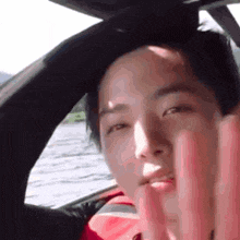 a man is giving the middle finger while sitting in a boat .