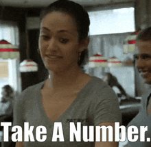 a woman says take a number while standing in a restaurant