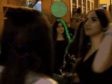 a woman in a black dress is standing in a crowd of people