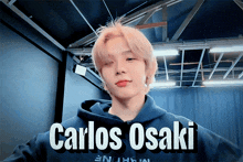 a young man wearing a blue hoodie with the name carlos osaka on it