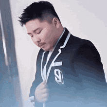 a man in a suit with the number 9 on his collar