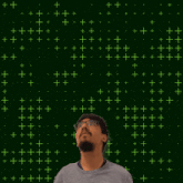 a man stands in front of a green background with the number 2