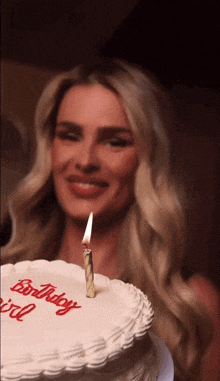 a woman lighting a candle on a birthday cake that says " birthday girl "