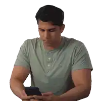 a man in a green shirt is using a cell phone