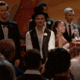 a man in a top hat stands in a crowd
