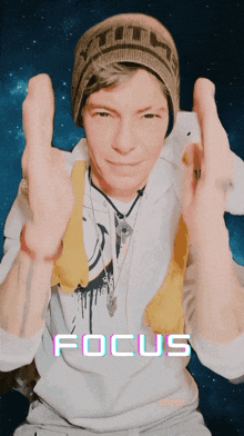 a man wearing a beanie and a white shirt with focus written on it