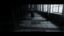 a person standing in a dark hallway with a reflection of a person 's face