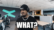 a man wearing headphones and a beanie says what in an office