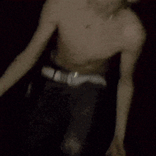 a shirtless man is making a peace sign with his hand