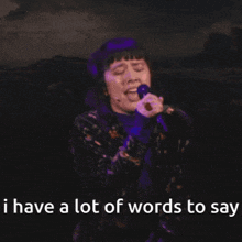 a woman singing into a microphone with the words i have a lot of words to say